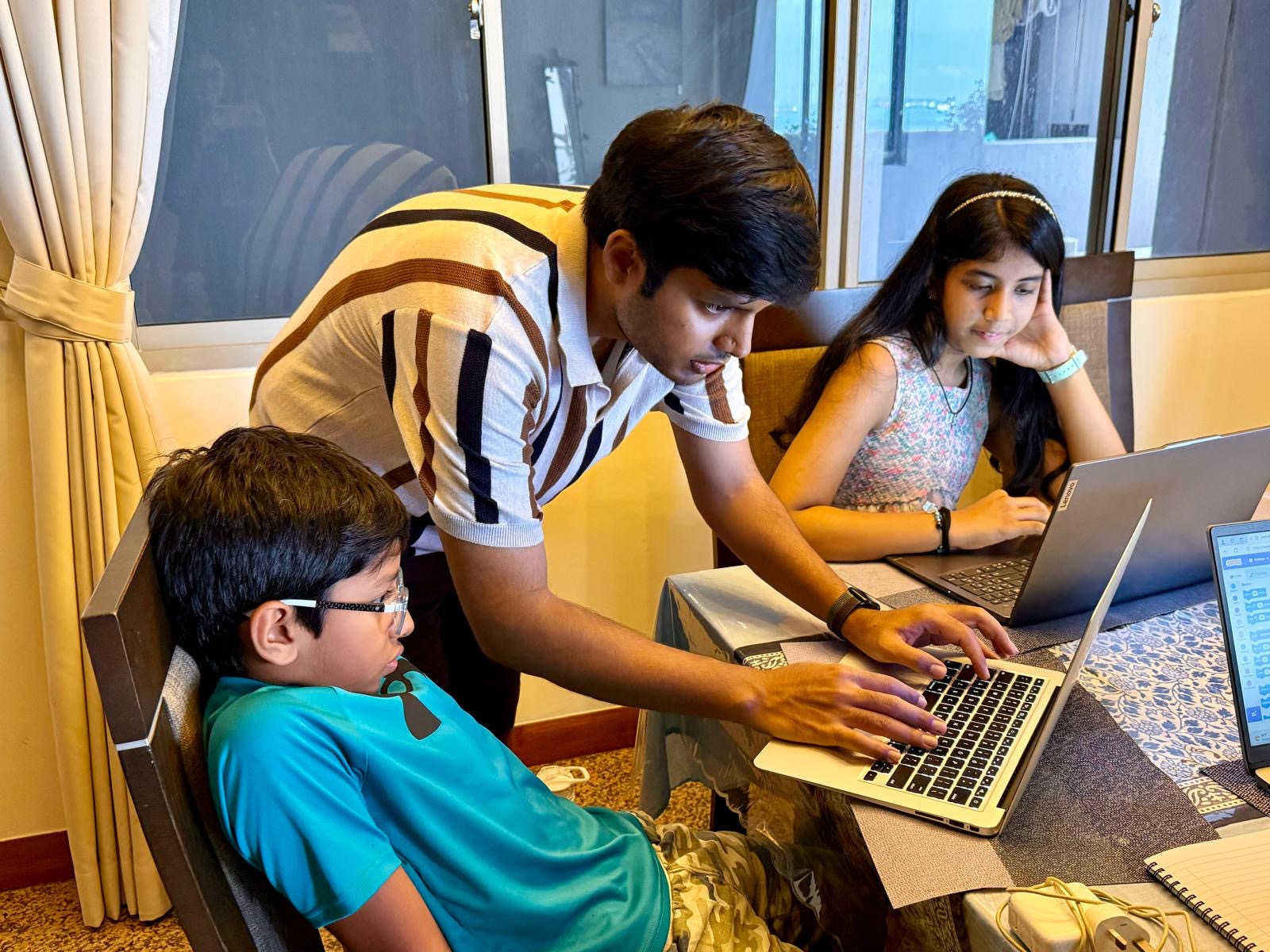 Kids coding on laptops with instructor